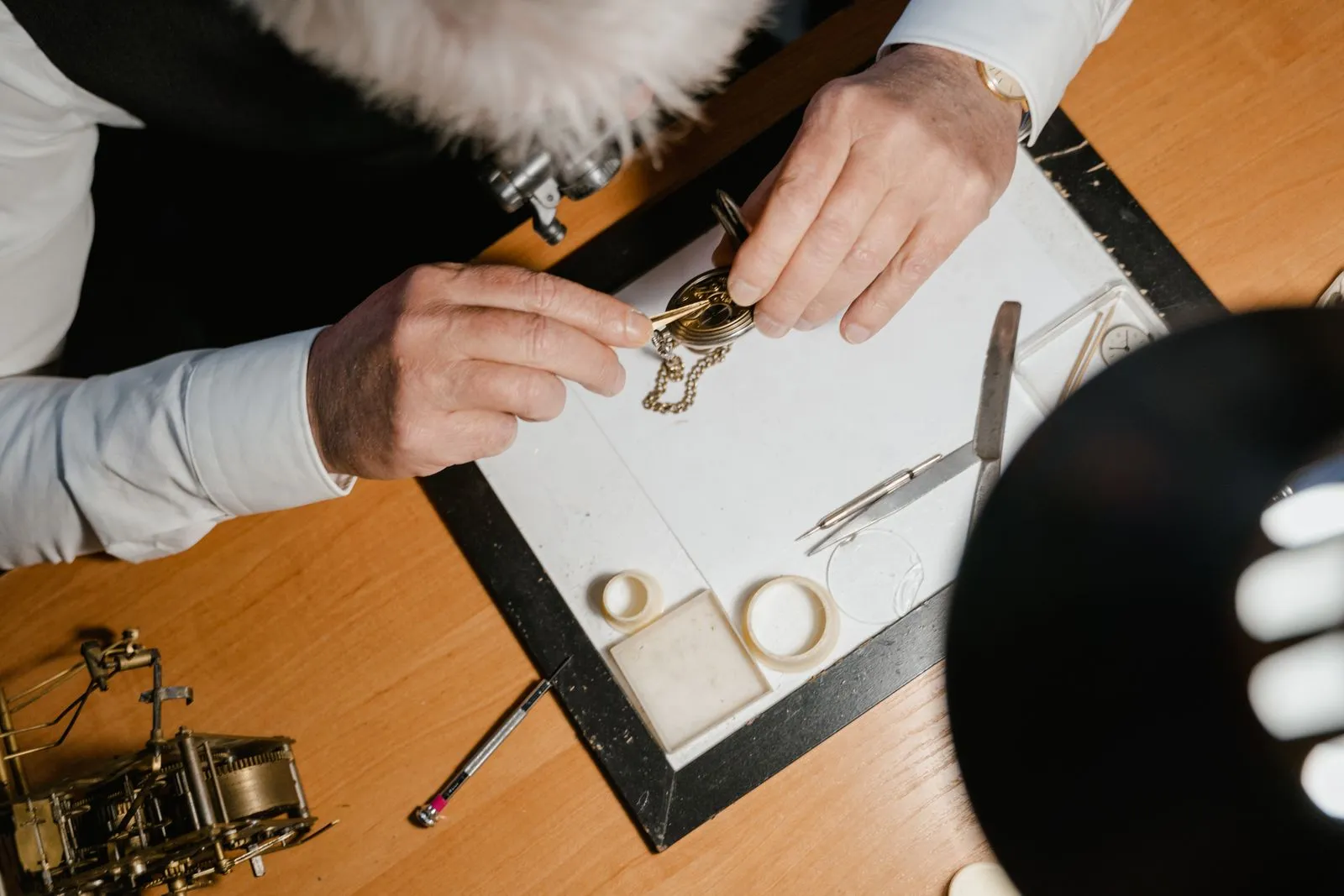 Close-up of a watchmaker's hands skillfully repairing a classic pocket watch.